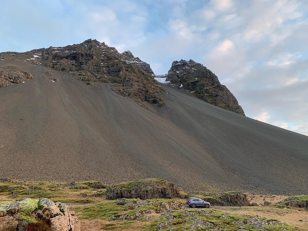A rental car parked beside a mountain in south-east Iceland.
